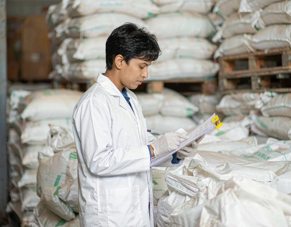 Quality control inspector checking a certificate of analysis for sodium lauryl sulfate raw material in a warehouse